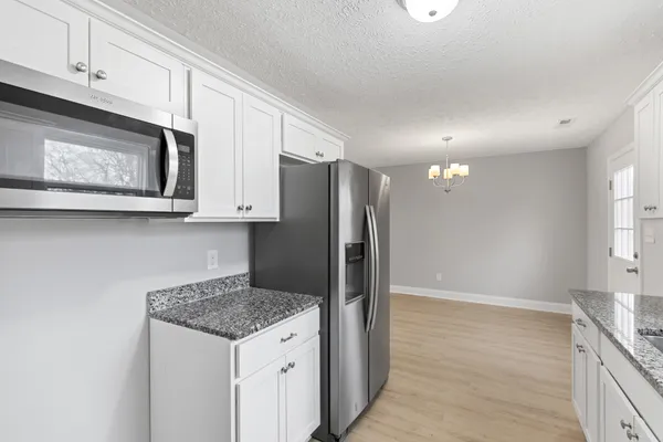 a kitchen with stainless steel appliances granite countertop a refrigerator and microwave