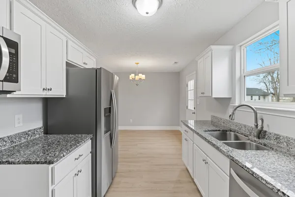 a kitchen with stainless steel appliances granite countertop a sink stove and refrigerator