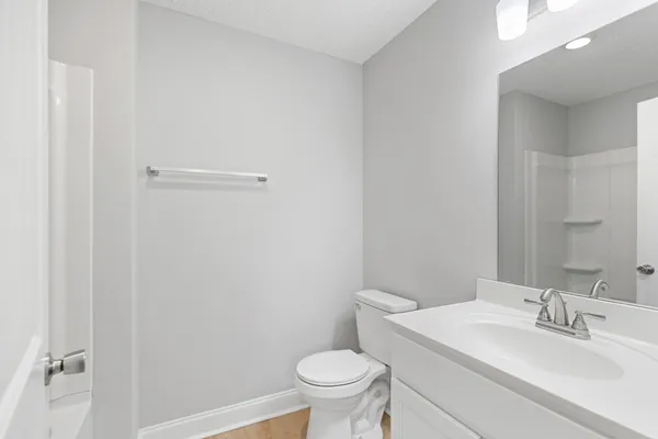 a bathroom with a sink a toilet and a mirror