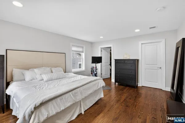 a large bedroom with a bed and wooden floor
