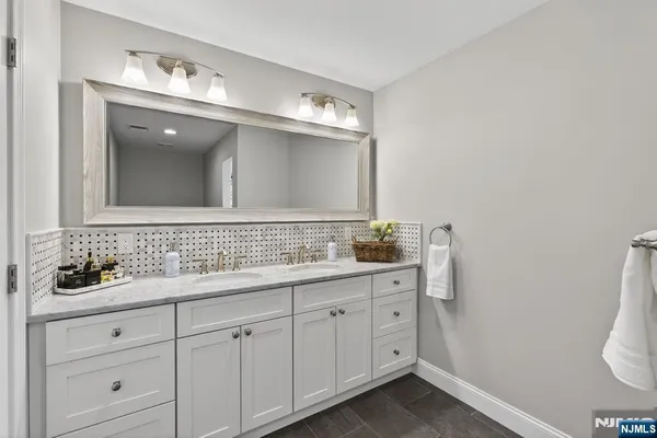 a bathroom with a double vanity sink and a mirror