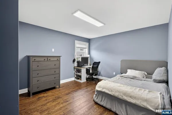 a bedroom with a large bed and a wooden floor
