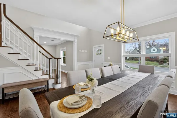a view of a dining room with furniture a chandelier and wooden floor