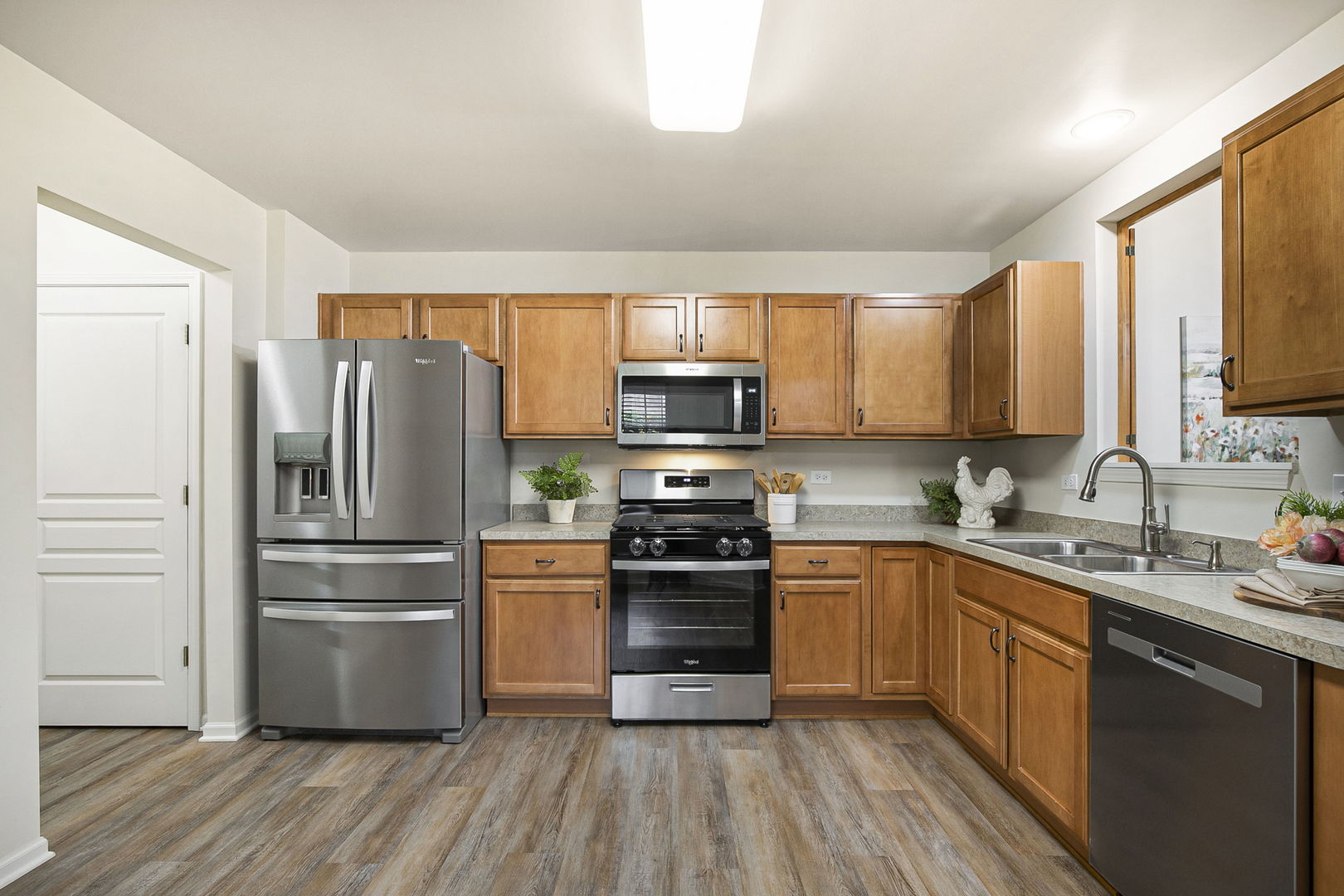 626 South Curran Road Round Lake, IL 60073 - Photo 11 of 25 a kitchen with stainless steel appliances granite countertop a refrigerator a stove top oven a sink dishwasher and wooden floor
