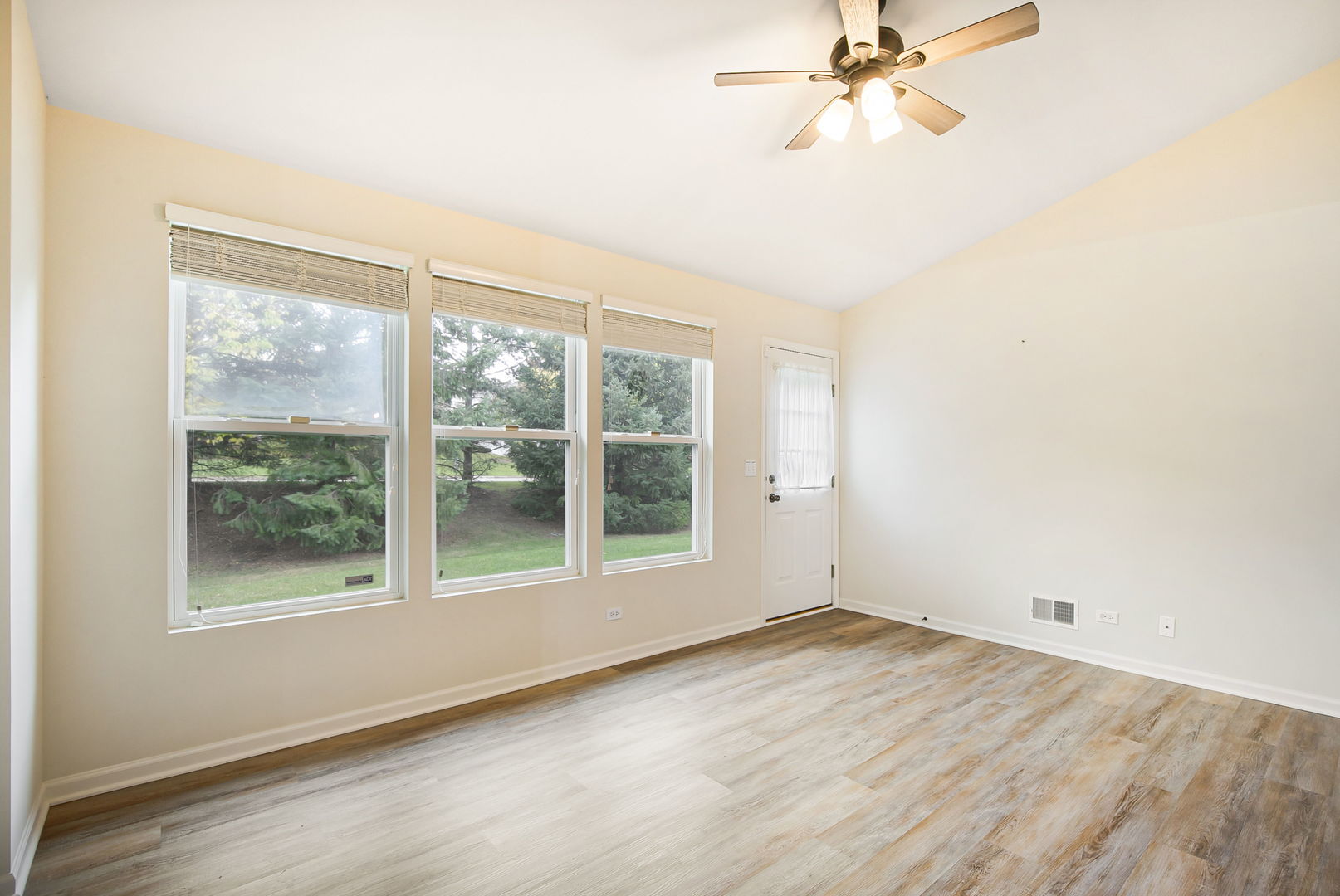 626 South Curran Road Round Lake, IL 60073 - Photo 10 of 25 an empty room with wooden floor fan and windows