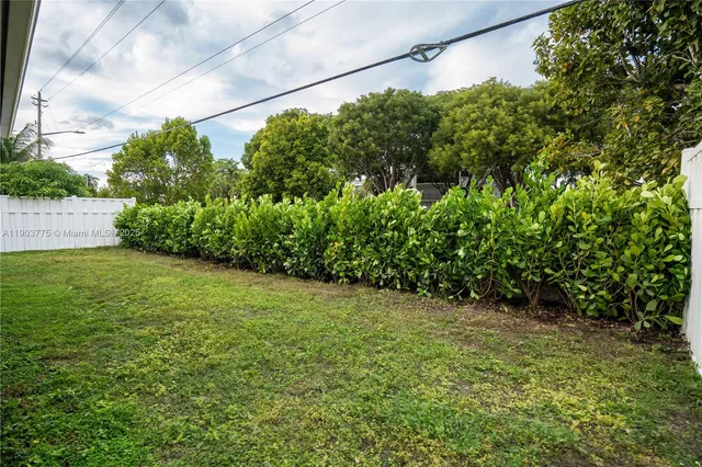 a view of a house with a yard and chairs