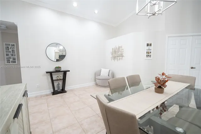 a dining room with wooden floor a chandelier a wooden table and chairs
