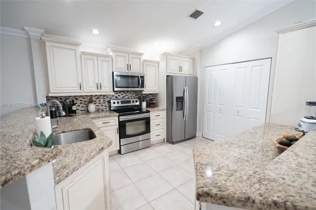 a kitchen with stainless steel appliances a stove sink and microwave