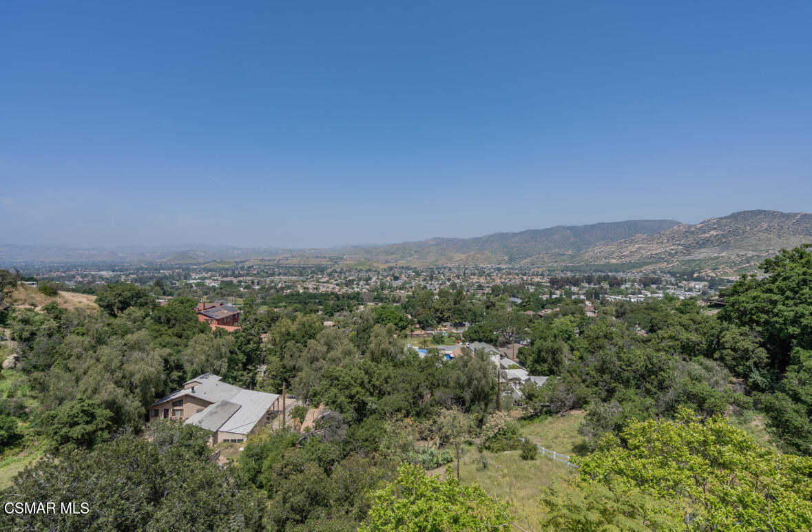 an aerial view of a city with lots of residential buildings and mountain view in back