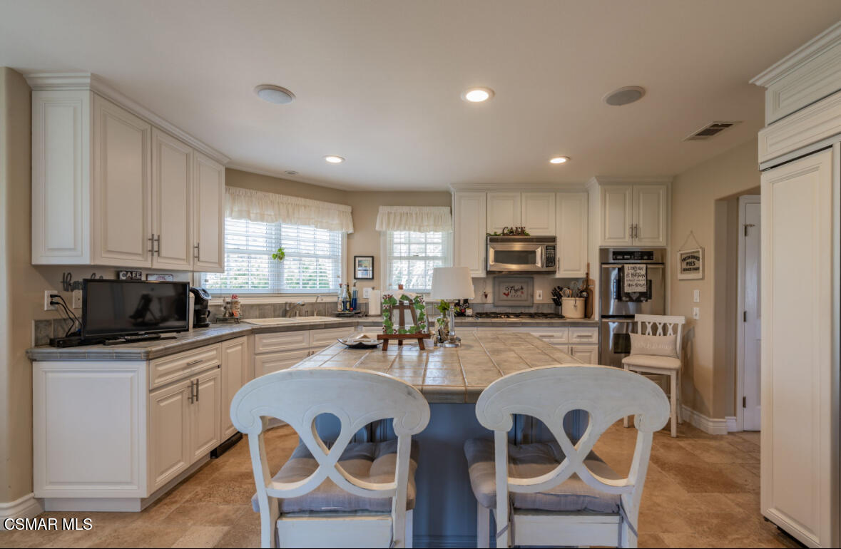 1029 Alta Vista Road Simi Valley, CA 93063 - Photo 2 of 20 a kitchen with refrigerator a microwave and chairs