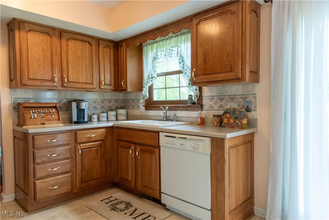 7969 Bricker Road Northwest Clinton, OH 44216 - Photo 8 of 23 Kitchen featuring dishwasher, oak cabinetry, and light countertops