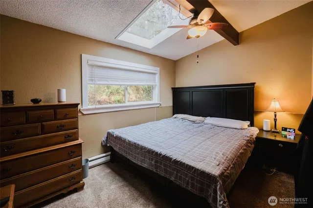 a bedroom with a bed and dresser with mirror