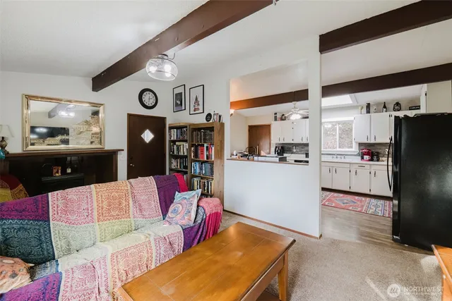 a living room with stainless steel appliances kitchen island granite countertop furniture and a view of kitchen