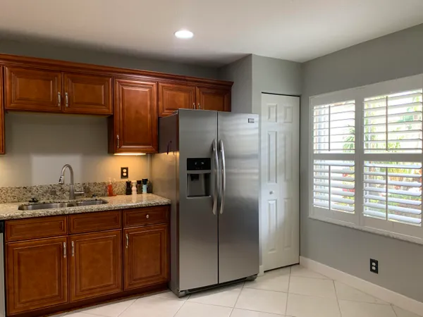 a kitchen with stainless steel appliances granite countertop a refrigerator sink and cabinets
