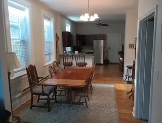 a dining room with furniture a chandelier and wooden floor
