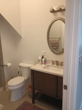 a bathroom with a toilet a sink and mirror