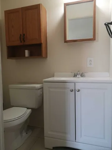 a bathroom with a toilet a sink and mirror