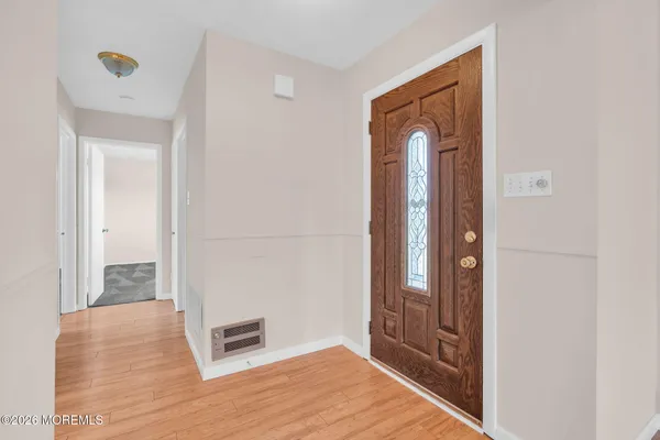 a view of a hallway with wooden floor and closet