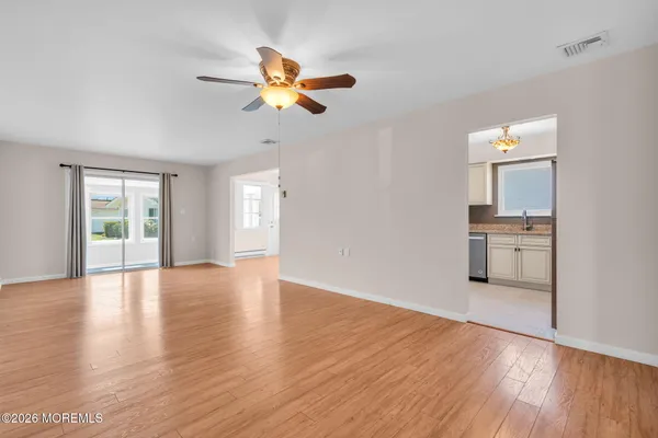 a view of a kitchen with wooden floor windows and a ceiling fan