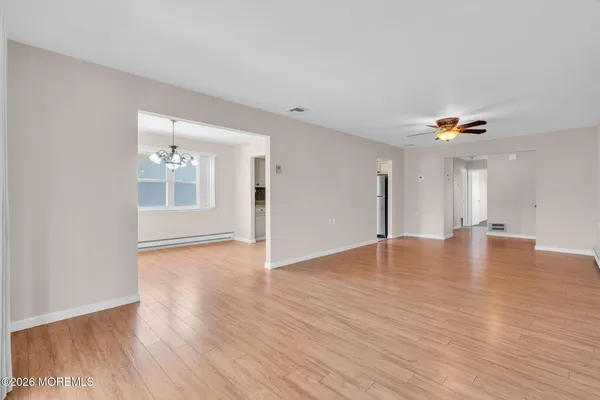 a view of empty room with wooden floor and ceiling fan