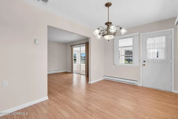 a view of an room with wooden floor chandelier and windows