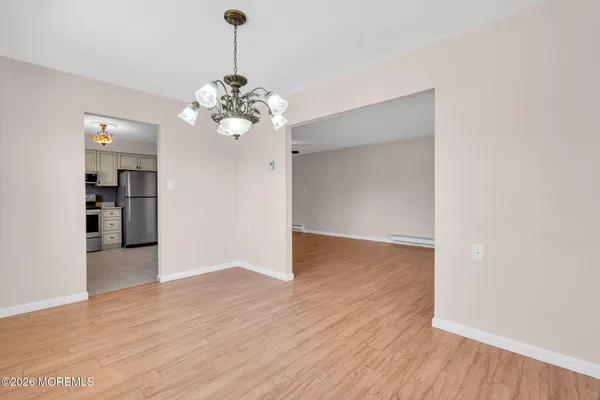 a view of a room with wooden floor and chandelier