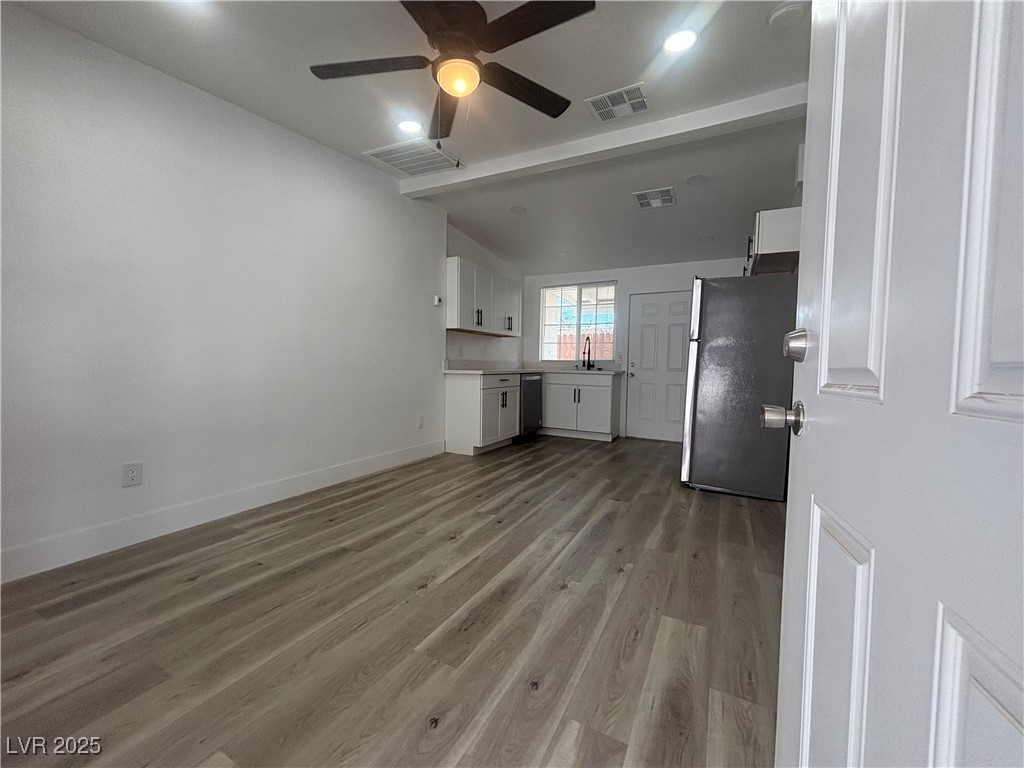 724 North 9th Street, Unit 2 Las Vegas, NV 89101 - Photo 2 of 10 Unfurnished living room with light wood-style floors, a ceiling fan, beamed ceiling, and recessed lighting