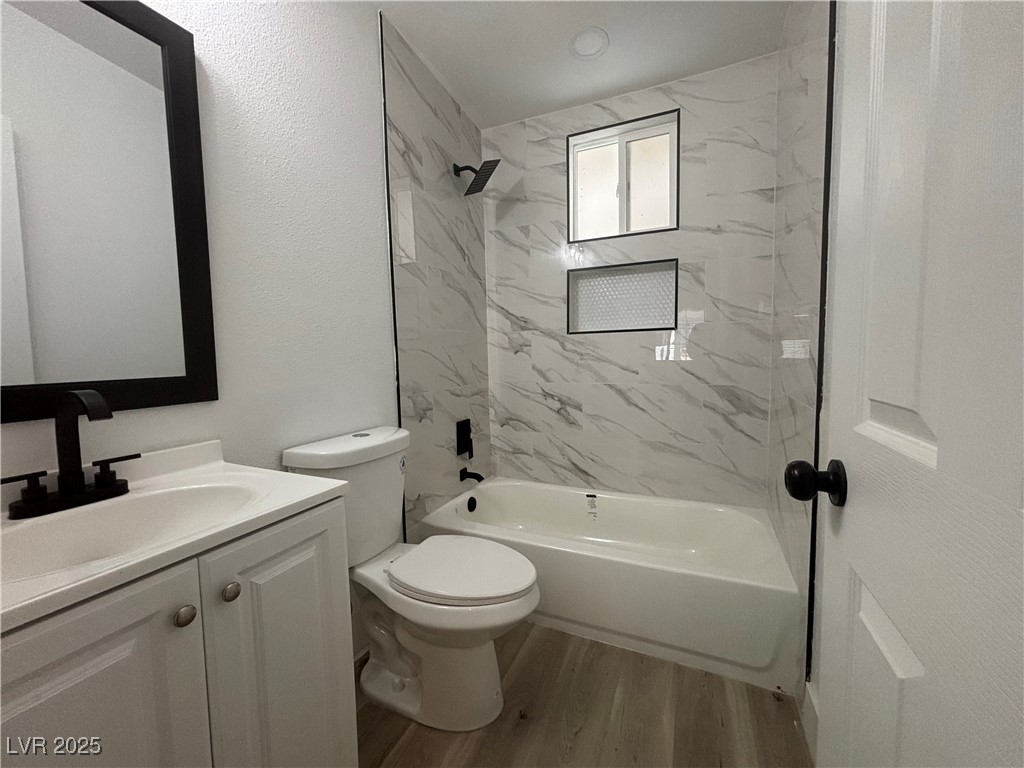 724 North 9th Street, Unit 2 Las Vegas, NV 89101 - Photo 7 of 10 Bathroom with shower / washtub combination, light wood-style flooring, vanity, and a textured wall