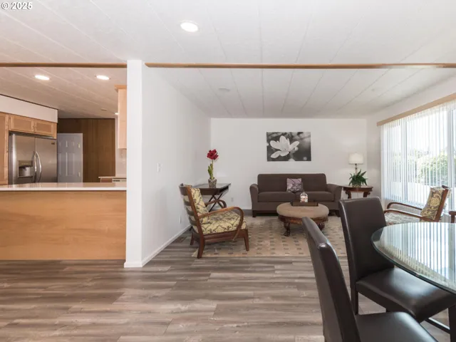 a dining room with furniture a chandelier and wooden floor