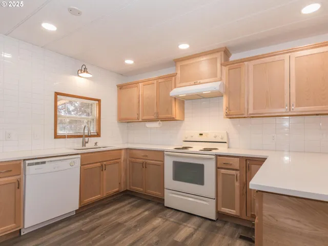 a kitchen with stainless steel appliances granite countertop a stove and white cabinets