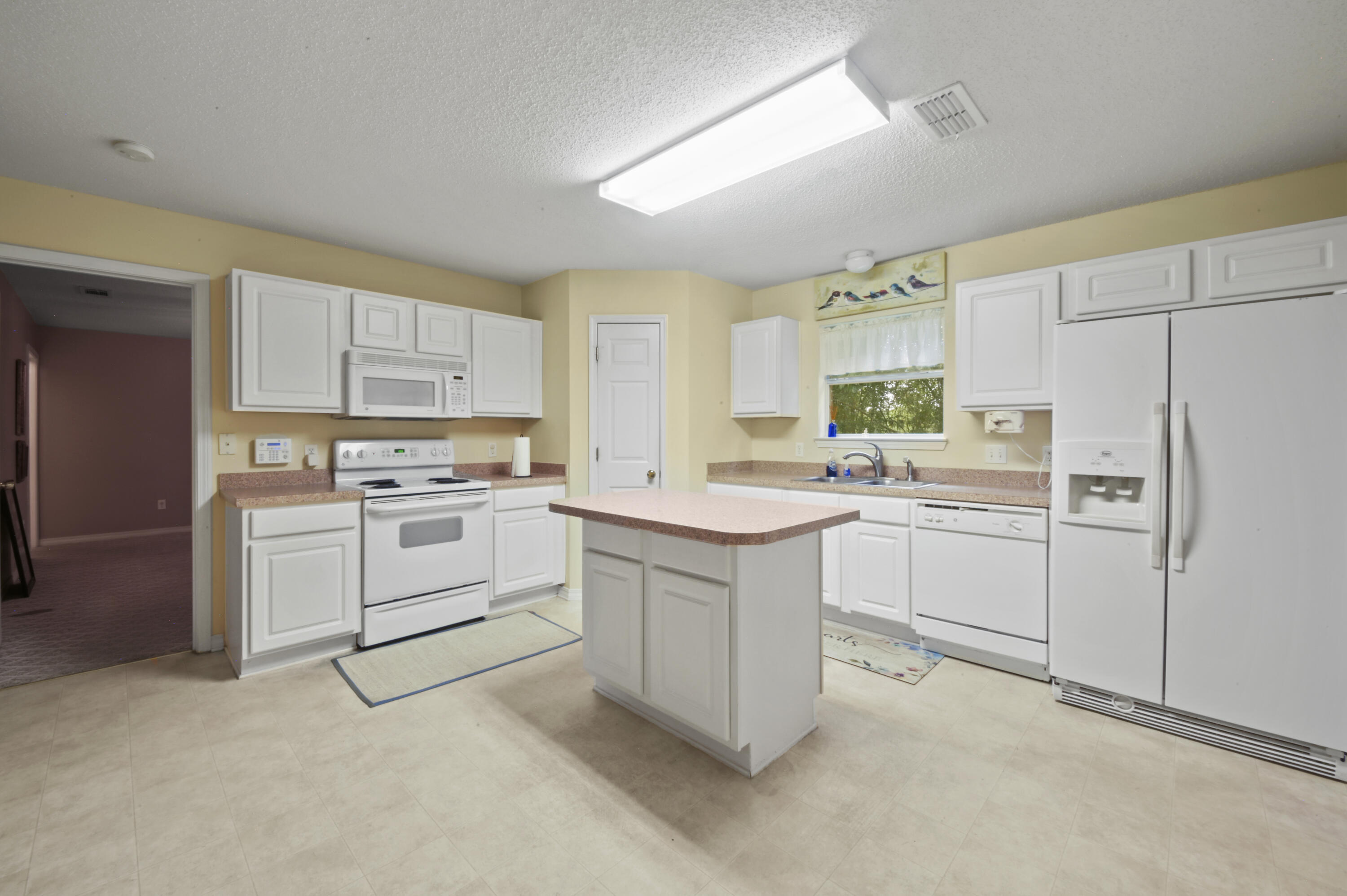 334 Egan Drive Crestview, FL 32536 - Photo 14 of 33 a kitchen with white cabinets and white appliances