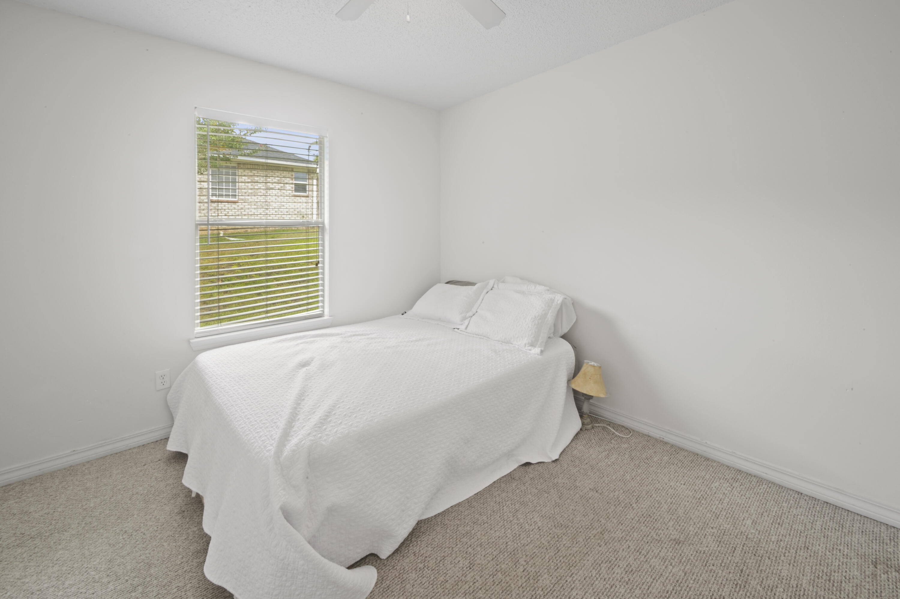 334 Egan Drive Crestview, FL 32536 - Photo 23 of 33 a bed sitting in a bedroom next to a window