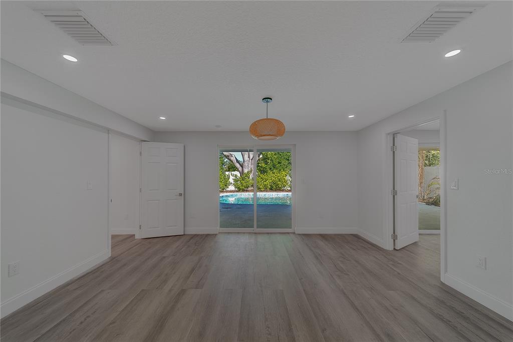 1152 Jackmar Road Dunedin, FL 34698 - Photo 11 of 60 an empty room with wooden floor and windows