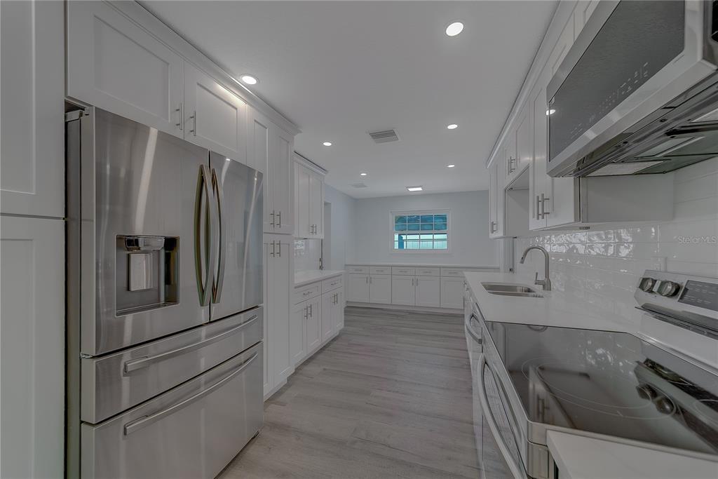 1152 Jackmar Road Dunedin, FL 34698 - Photo 13 of 60 a kitchen with stainless steel appliances granite countertop a refrigerator and a stove