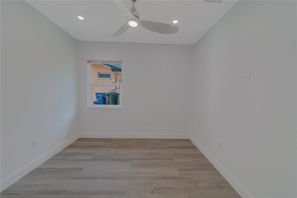 1152 Jackmar Road Dunedin, FL 34698 - Photo 39 of 60 an empty room with wooden floor and windows