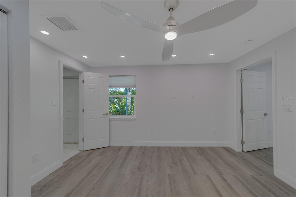 1152 Jackmar Road Dunedin, FL 34698 - Photo 46 of 60 an empty room with wooden floor and windows