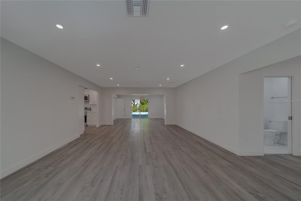1152 Jackmar Road Dunedin, FL 34698 - Photo 8 of 60 a view of an empty room with wooden floor and a window