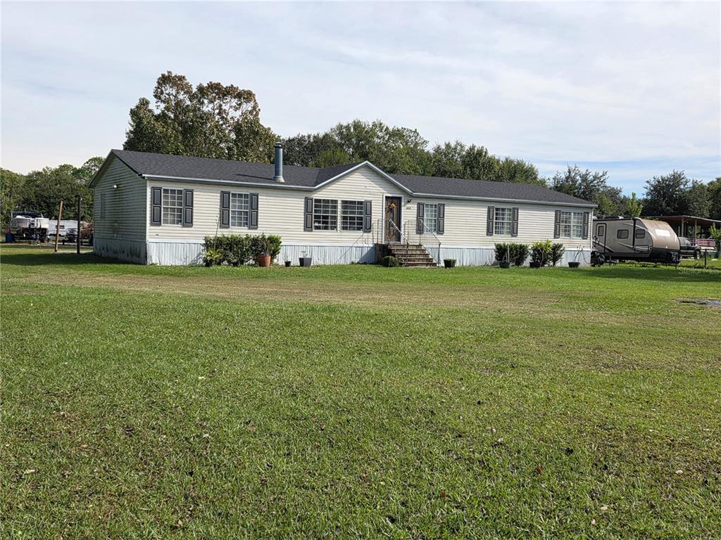 3935 Rambler Avenue St. Cloud, FL 34772 - Photo 3 of 36 a front view of a house with a garden