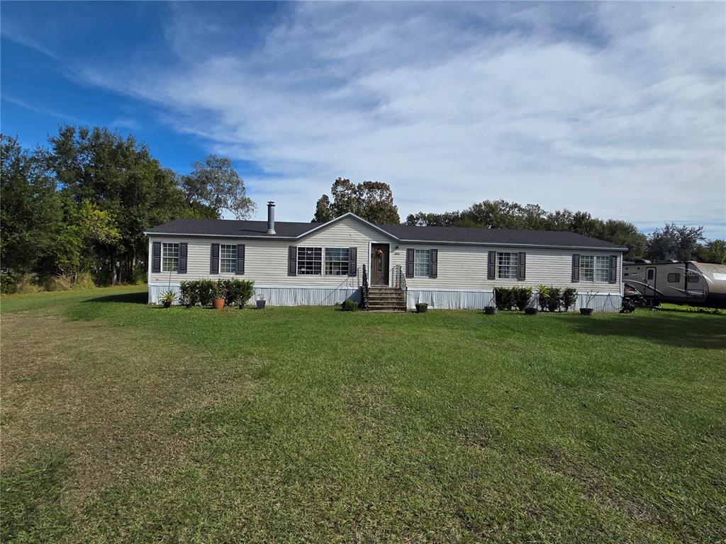 3935 Rambler Avenue St. Cloud, FL 34772 - Photo 4 of 36 a front view of a house with a garden