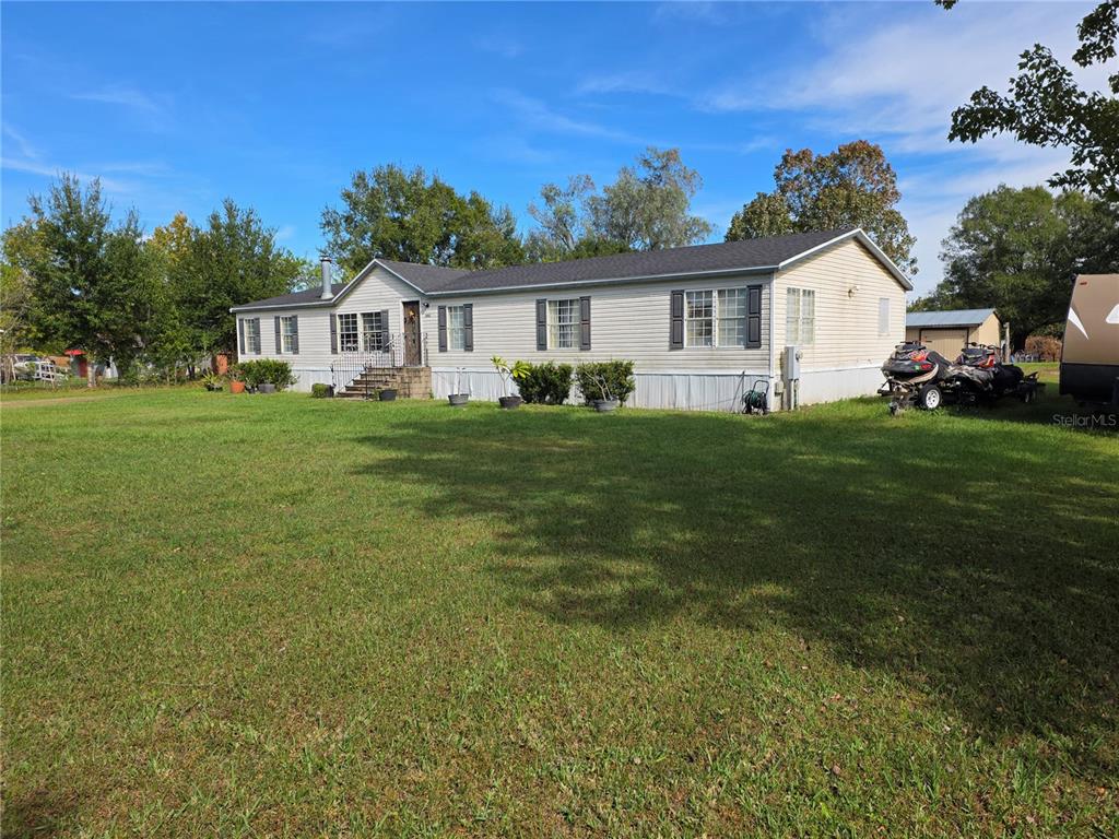 3935 Rambler Avenue St. Cloud, FL 34772 - Photo 7 of 36 a front view of a house with a garden