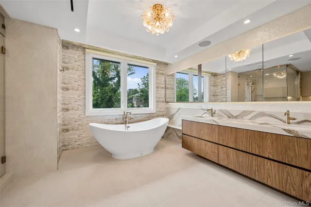 a bathroom with a granite countertop tub sink and mirror