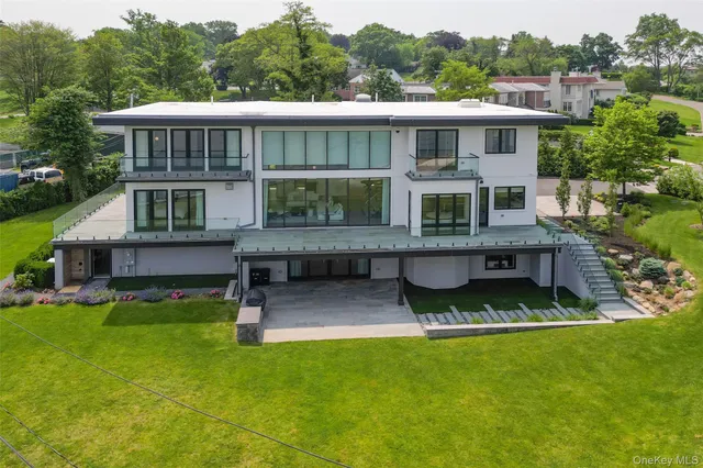 a view of a house with a big yard plants and large trees