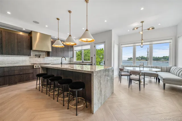 a kitchen with stainless steel appliances granite countertop table chairs and a view of living room
