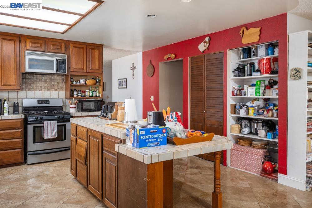 4591 Edwards Lane Castro Valley, CA 94546 - Photo 6 of 44 a kitchen with stainless steel appliances a stove top oven a dining table and chairs