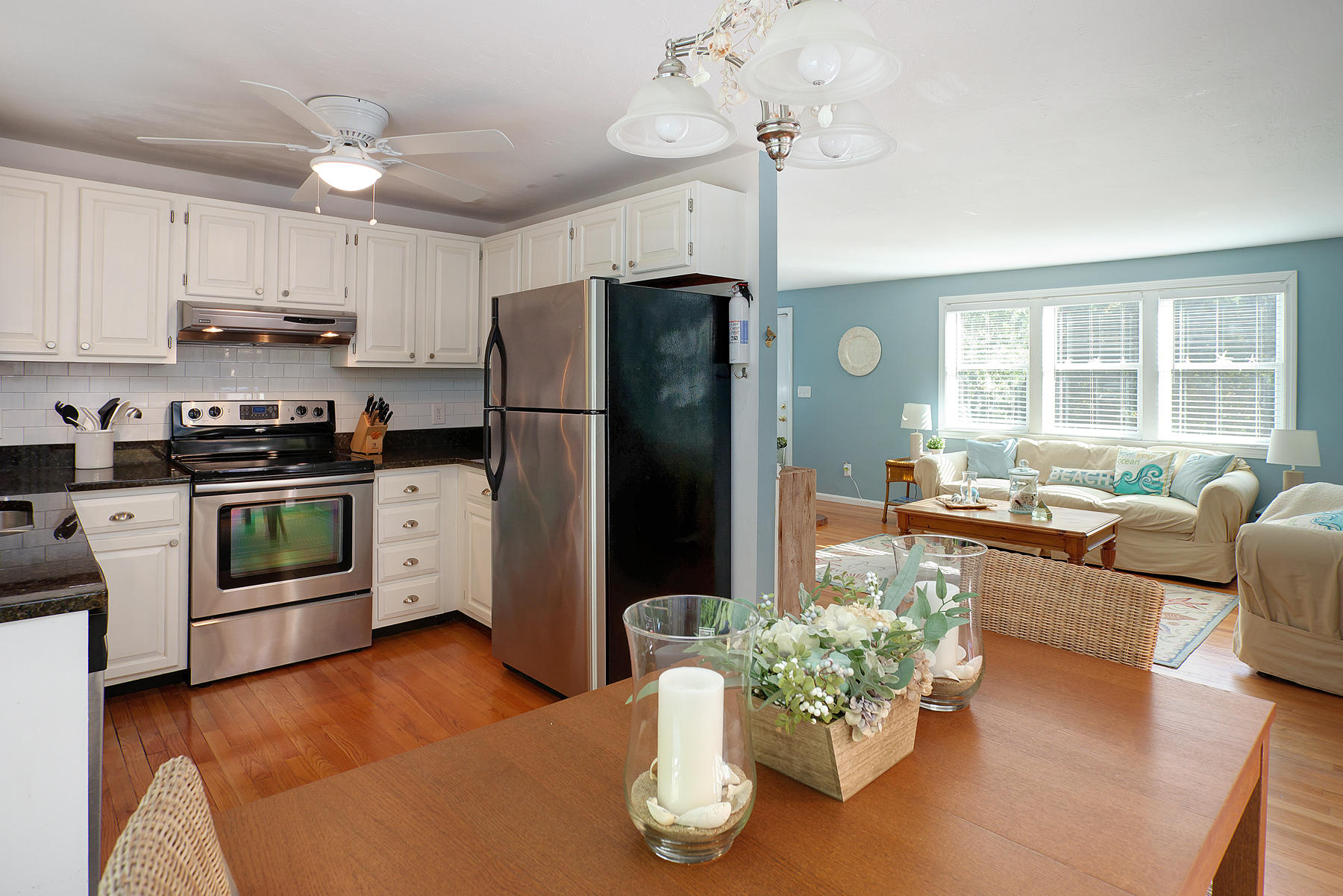 132 Harbor Hills Road Centerville, MA 02632 - Photo 8 of 31 a kitchen with stainless steel appliances granite countertop a refrigerator a sink dishwasher a stove a dining table and chairs with wooden floor