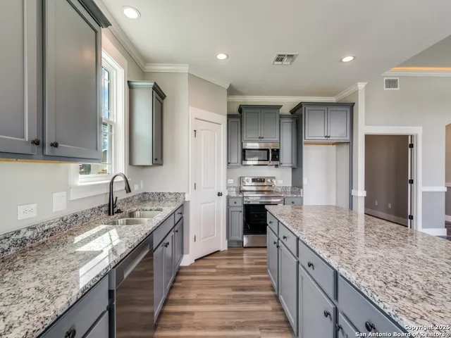 a kitchen with stainless steel appliances granite countertop a sink stove and refrigerator