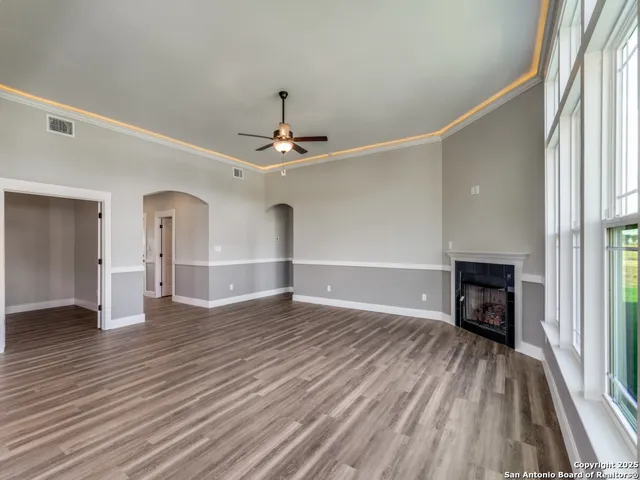 a view of empty room with wooden floor and fireplace