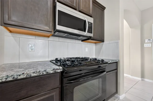 a stove top oven sitting inside of a kitchen