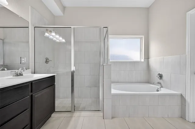 a bathroom with a bathtub shower sink vanity granite and a shower