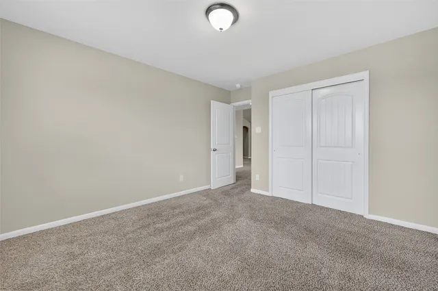 an empty room with closet and fan